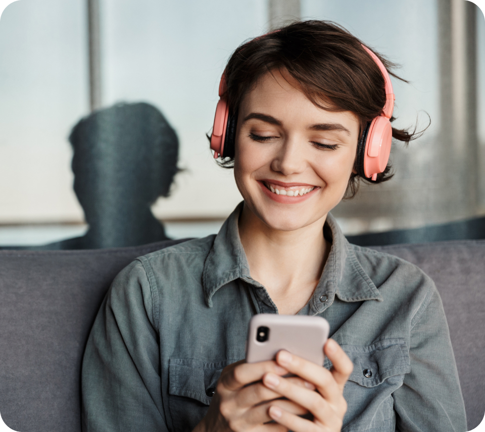 A person looking at her phone, wearing headphones