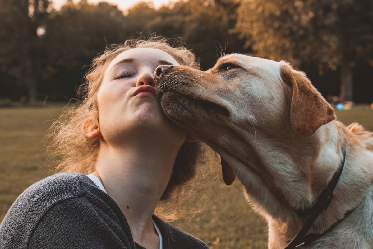 A girl kissing her dog